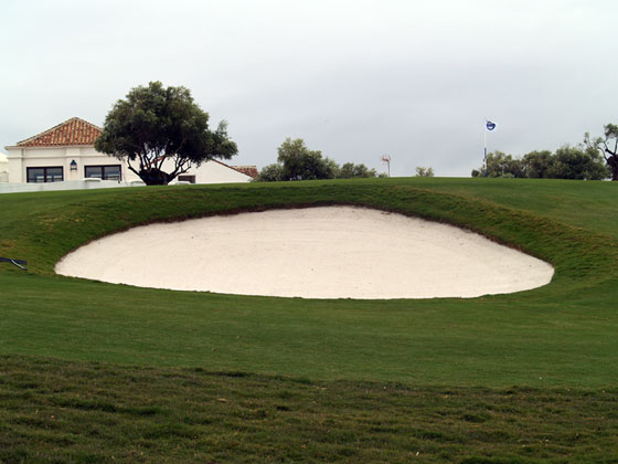 ¿Dónde creen ustedes que está el tapón en esta trampa de arena del hoyo 9 de Finca Cortesín?
