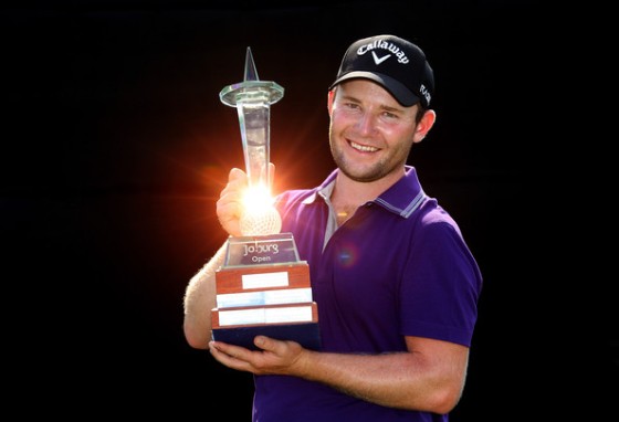 Branden Grace posa sonriente con el trofeo de ganador del Joburg Open.