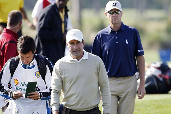 Álex Larrazábal consulta la libreta junto a Chema Olazábal, al fondo, Davis Love III.
