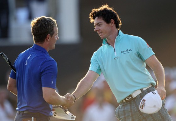 Rory McIlroy estrecha la mano de Luke Donald tras la primera vuelta del Dubai World Championship.