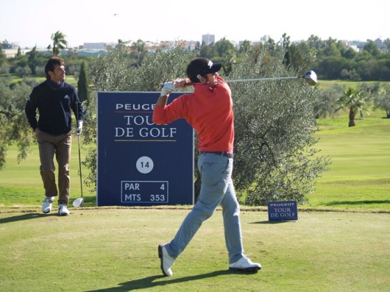 Eduardo de la Riva pega su golpe de salida hoy en la primera jornada de la Final del Peugeot ante la mirada de Carlos Rodiles.