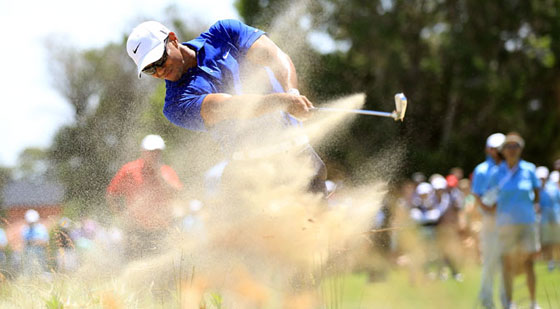 Tiger Woods le pega desde la arena en el hoyo 3 de su recorrido hoy en Australia.