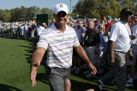 Tiger tiende la mano a un aficionado en su regreso a los campos a principios de temporada.