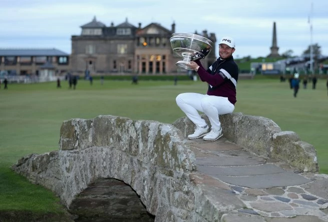 Tyrrell Hatton of England celebrates victory with the trophy on the Swilken Bridge following the final round of the 2017 Alfred Dunhill Championship at The Old Course on October 8, 2017 in St Andrews, Scotland. (Photo by Richard Heathcote/Getty Images)