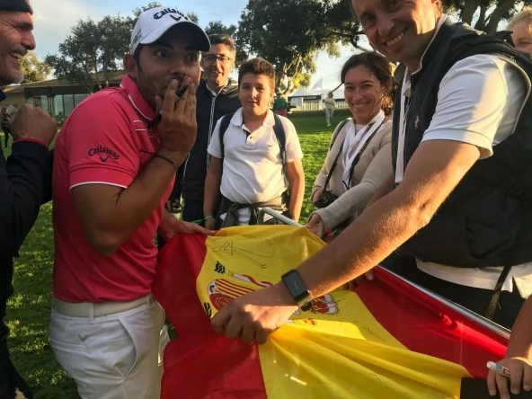 Pablo Larrazábal firma una bandera de España a unos aficionados en Valderrama. © Tengolf