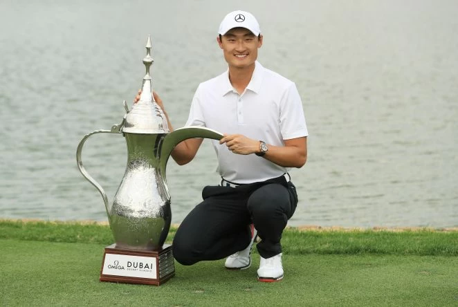 Haotong Li of China celebrates victory with the trophy after the final round on day four of the Omega Dubai Desert Classic at Emirates Golf Club on January 28, 2018 in Dubai, United Arab Emirates. (Photo by Andrew Redington/Getty Images)