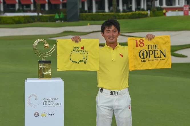 Takumi Kanaya posa con el trofeo del Asia-Pacific Amateur Championship y las banderas del Masters y del Open. © Golffile | Ken Murray