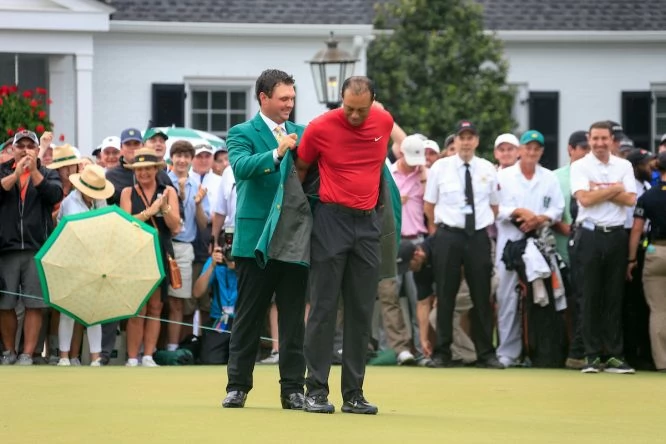 Momento en el que Patrick Reed coloca a Tiger Woods la Chaqueta Verde de ganador del Masters de Augusta 2019. © Golffile | Fran Caffrey