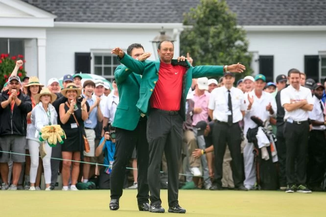 Tiger Woods recibe la Chaqueta Verde de su predecesor, Patrick Reed. © Golffile | Fran Caffrey