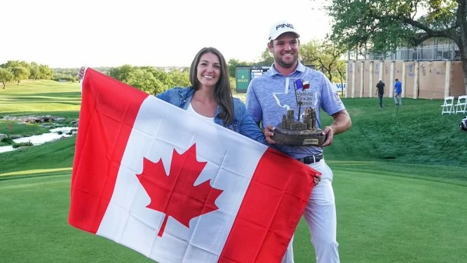 Corey Conners posa con su mujer, el trofeo del Valero Texas Open y la bandera de Canadá. © PGA Tour