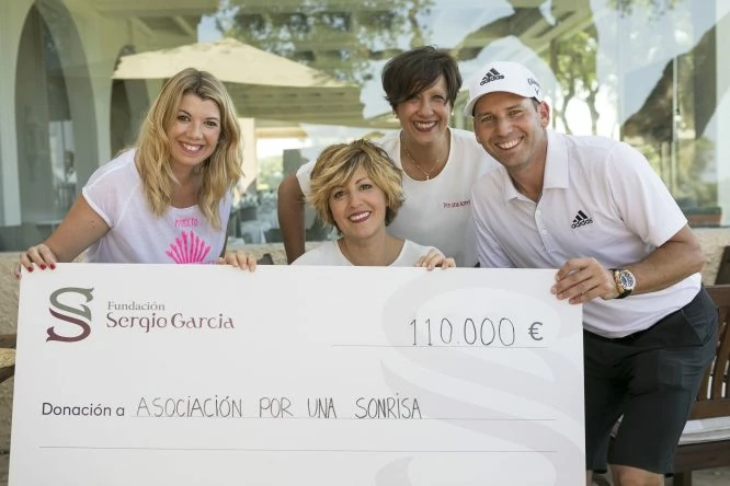 Sergio García hace entrega del cheque de la recaudación de la edición 2018 del torneo a la representantes de la asociación 
