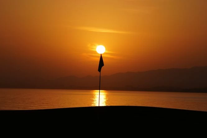 Puesta del sol en el hoyo 18 del Al Mouj Golf. © Golffile | Thos Caffrey