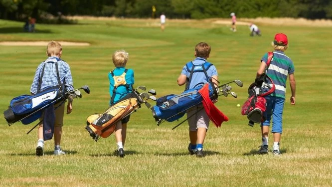 Un grupo de niños jugando al golf