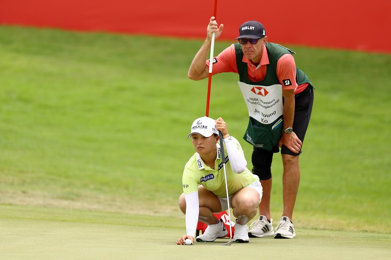 Jin Young Ko of South Korea lines up her putt with her caddie on the 18th green the third round of the HSBC Women's World Championship at Sentosa Golf Club on March 05, 2022 in Singapore. (Photo by Yong Teck Lim/Getty Images)